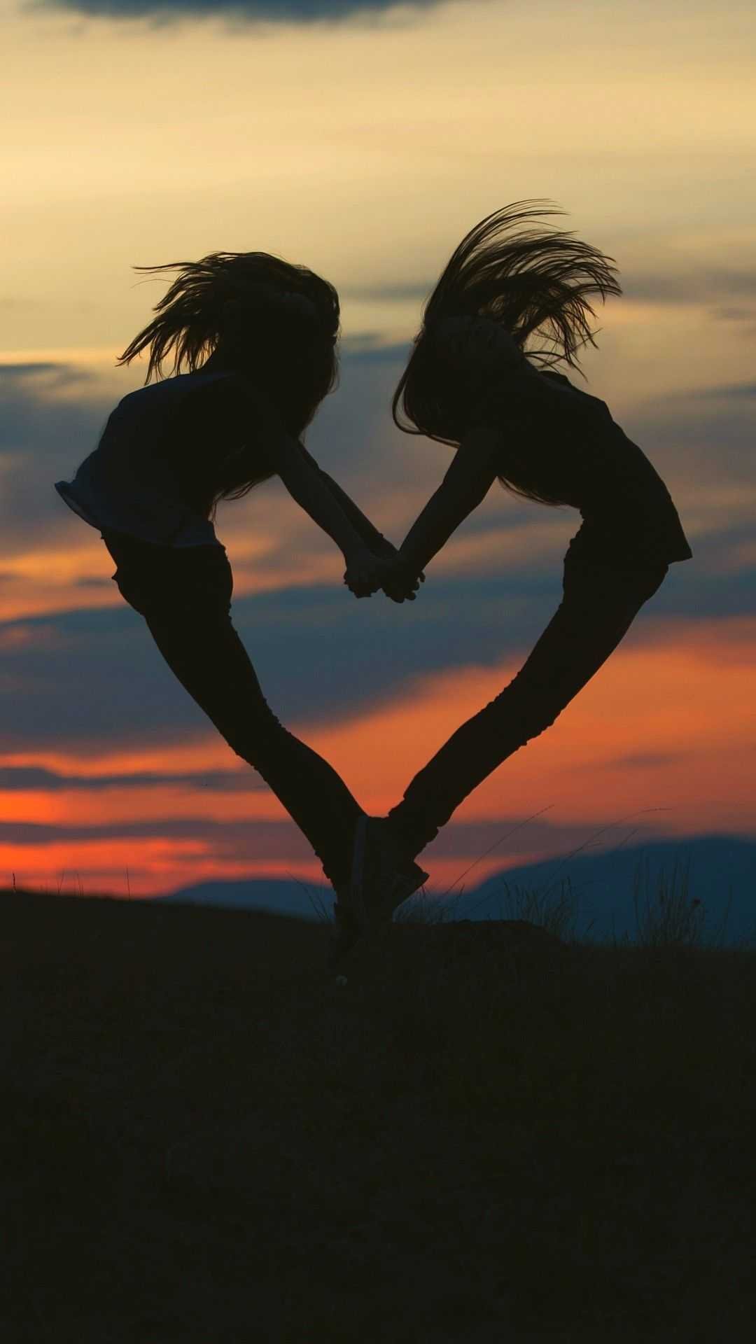 two best friends holding hands in the sunset