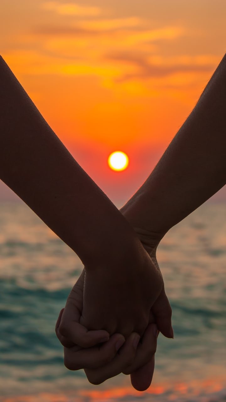 holding hands sunset
