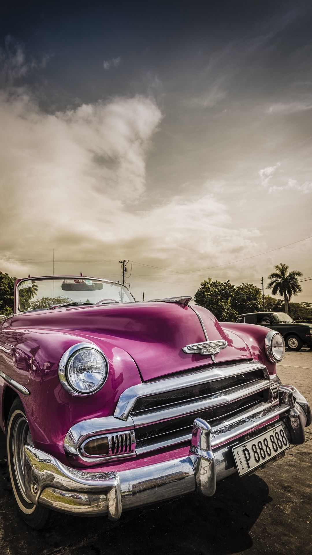 A Pink Vintage Car Parked In A Parking Lot